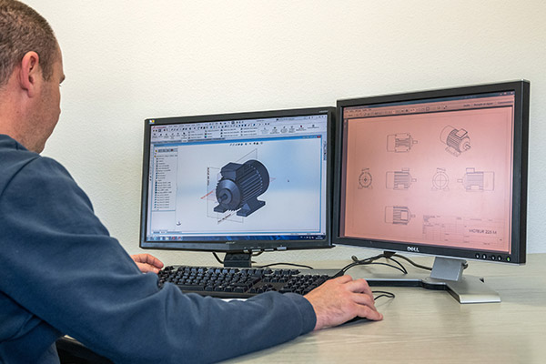Technicien sur un ordinateur, double écrans, conception de pièces industriels